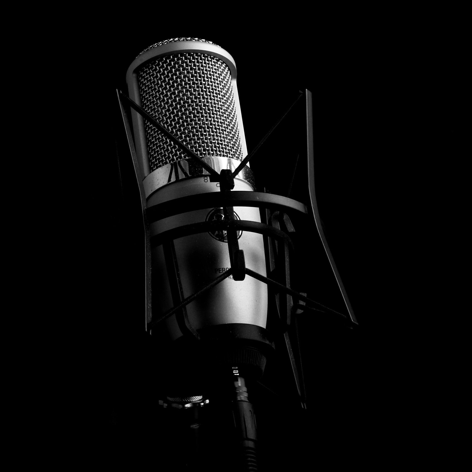 pexels photo 11417436 11417436 Close-up view of a professional studio microphone set against a black background, ideal for audio and recording themes.